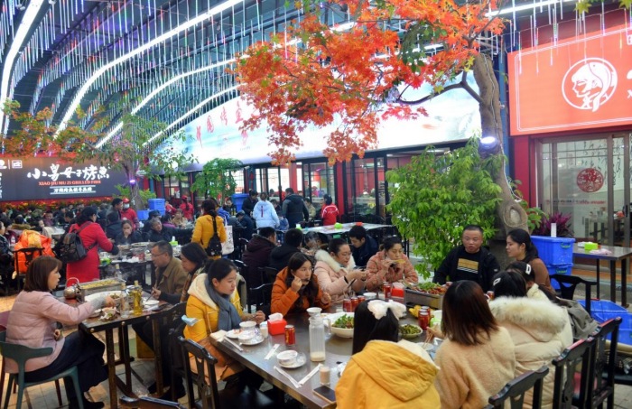 萬州區(qū)心連心廣場(chǎng)，市民品嘗鮮香烤魚。付作僑攝