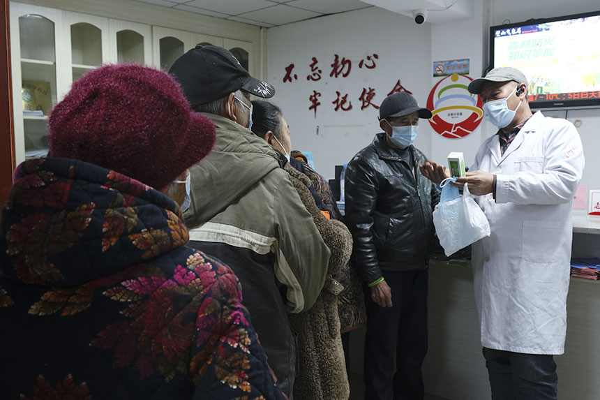 老人領(lǐng)到“健康包”后，醫(yī)生在旁耐心講解。蔣永勁攝