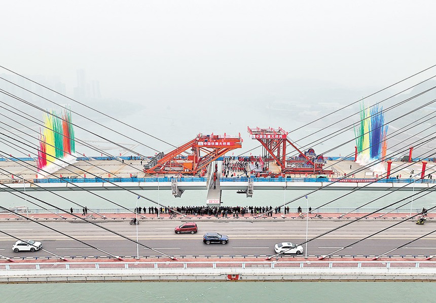 1月12日，軌道交通18號線李家沱長江復線橋?qū)崿F(xiàn)合龍。圖為中鐵建技術工人在合龍現(xiàn)場進行最后一節(jié)鋼箱梁吊裝。記者 羅斌 攝/視覺重慶