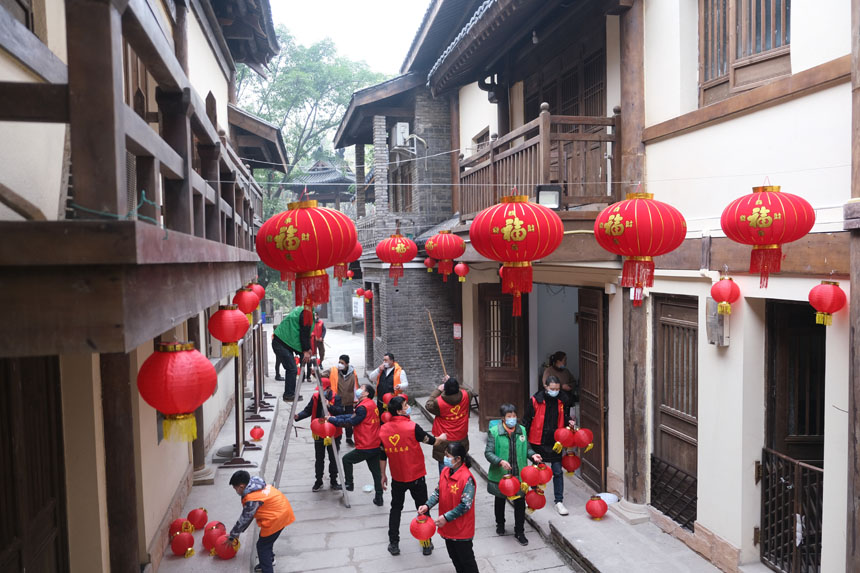 志愿者們正在為黃葛古道敦厚坡段的傳統(tǒng)民居貼春聯(lián)，掛燈籠。郭旭攝
