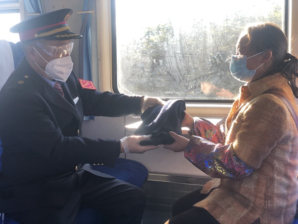 吳洪江帶給村民鄭啟梅丈夫的嶄新毛背心。張章攝