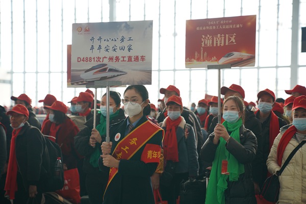 重慶西站工作人員舉牌引導(dǎo)外出務(wù)工人員有序上車。魏偉攝