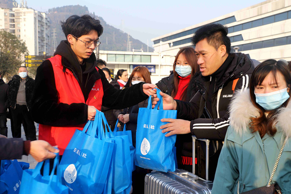 志愿者為務(wù)工人員送上返崗“大禮包”。李歆宇攝