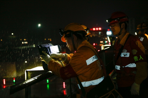 圖為何雪正在檢修興隆場編組站燈橋上的探照燈。冉杰攝