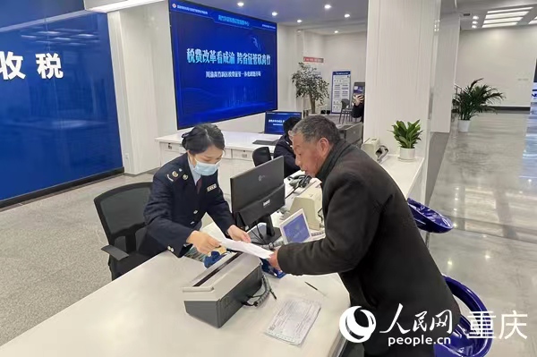 川渝高竹新區(qū)稅費(fèi)征管中心工作人員為納稅人開(kāi)票。人民網(wǎng) 胡虹攝