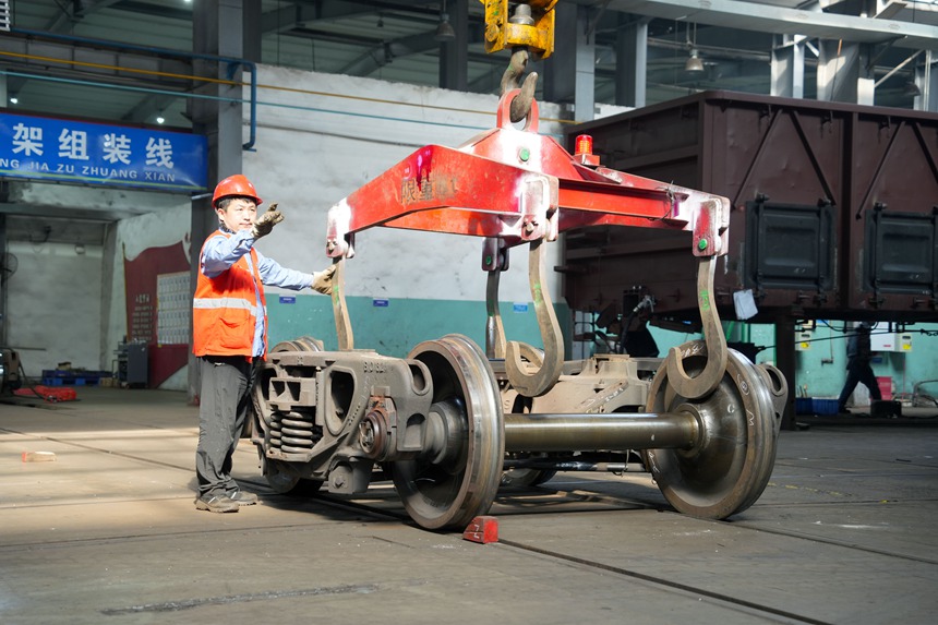 車輛鉗工正在進(jìn)行轉(zhuǎn)向架吊運(yùn)作業(yè)。吳晉超攝