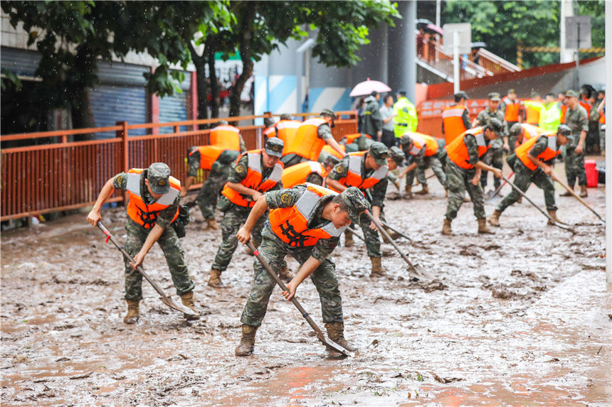 圖為武警官兵清理街道淤泥。李東攝
