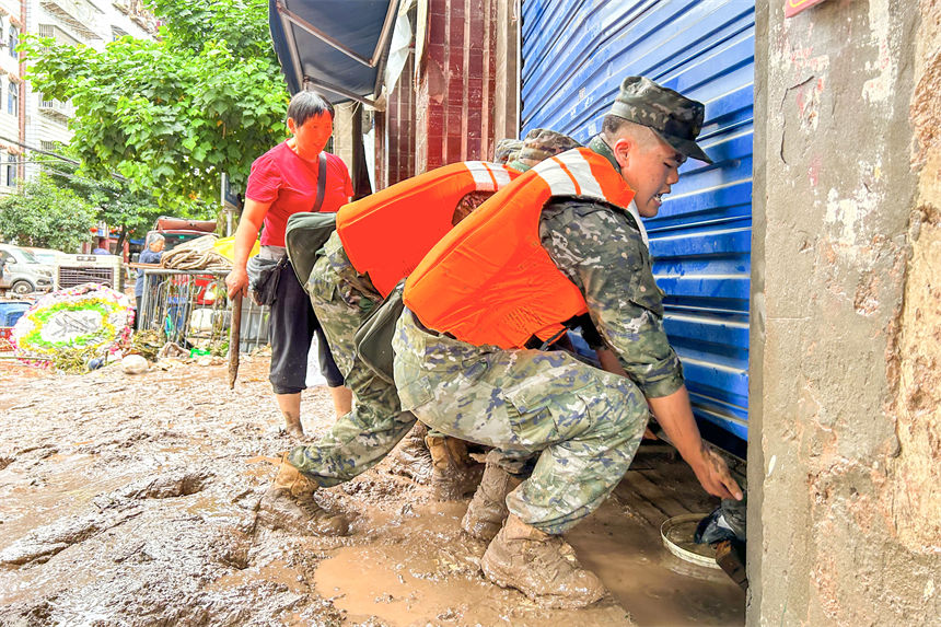 圖為武警官兵幫助受災(zāi)群眾轉(zhuǎn)移物資。李東攝