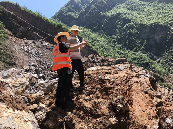 《身先士卒》。2022年6月30日，巫溪縣滑坡?lián)岆U工作中，炎炎烈日下 ，重慶市規(guī)劃和自然資源局地勘處處長李少榮（右）與208地質(zhì)隊專業(yè)總工蔣先念現(xiàn)場討論滑坡?lián)岆U方案。黎中余攝
