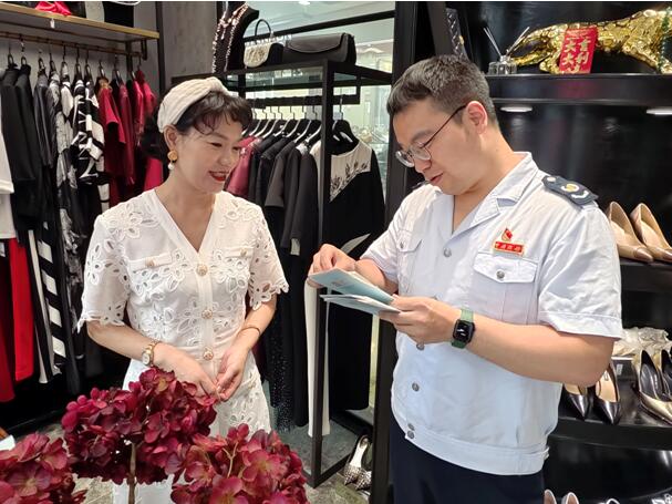 渝中區(qū)稅務(wù)人員來到朝天門綜合交易市場，為商戶講解個體工商戶相關(guān)稅費(fèi)優(yōu)惠政策。胡鑫攝