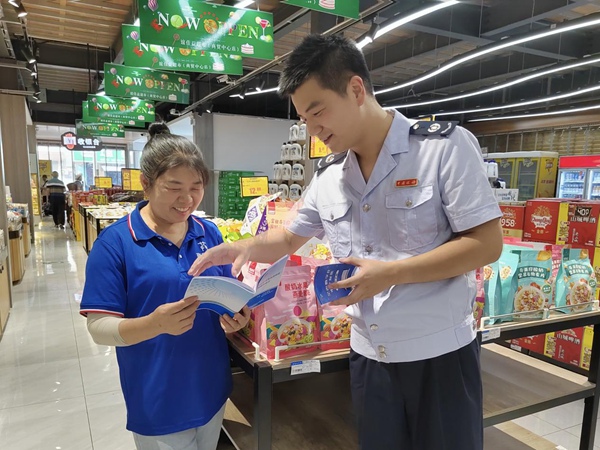 巫山縣稅務人員來到當?shù)爻?,送上批發(fā)零售業(yè)稅收優(yōu)惠政策宣傳冊。羅超斌攝
