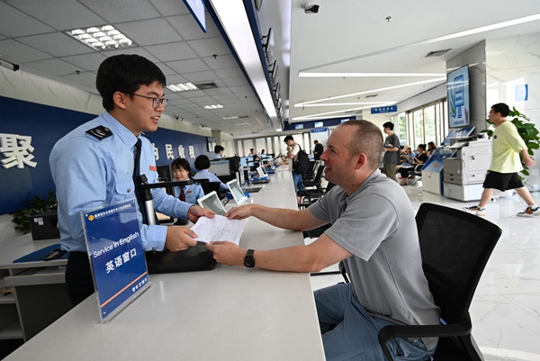 江北區(qū)第一稅務(wù)所英語專窗工作人員用英文與外籍人員溝通，協(xié)助其辦理退稅。馬梁峰攝