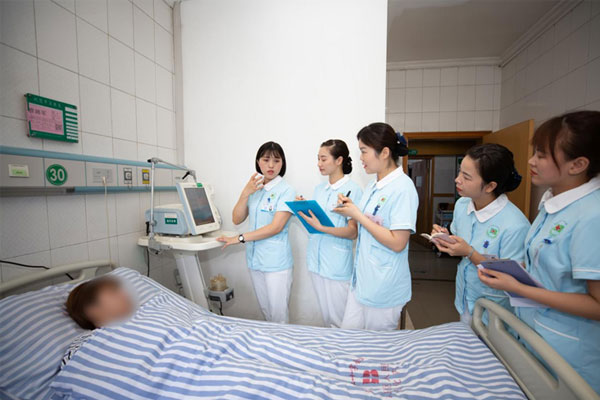 羅洪清（左一）帶領(lǐng)團隊查看患者身體指標。重慶市紅十字會醫(yī)院（江北區(qū)人民醫(yī)院）供圖