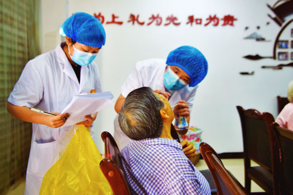 醫(yī)生為老年人進(jìn)行口腔檢查。陶涵攝