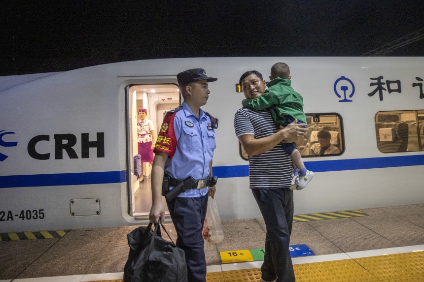 黃同川幫助旅客下車出站。胡勇攝