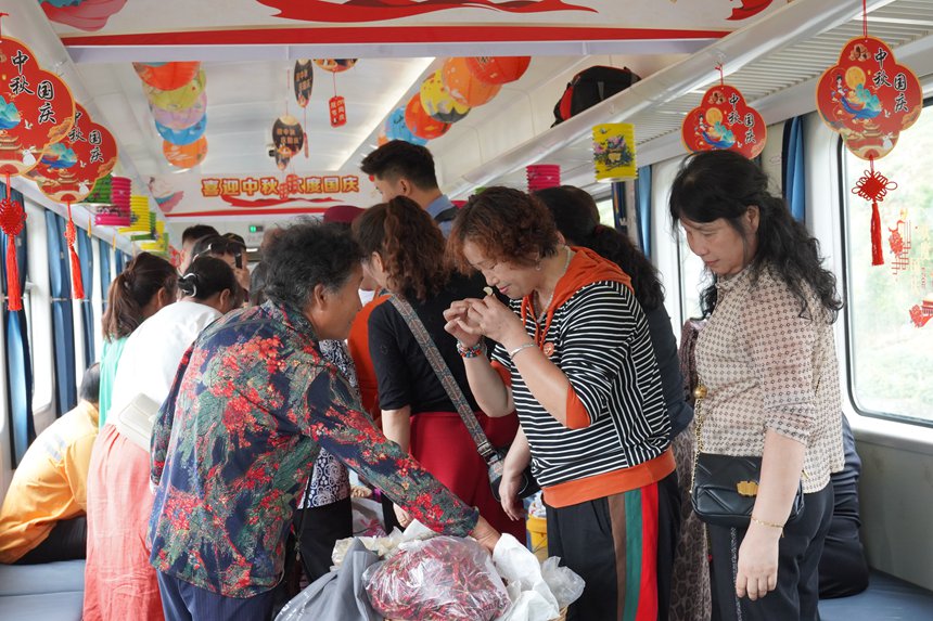 遵義開往重慶西的5630次列車上，旅客在集市車廂購買農(nóng)產(chǎn)品。李文航攝