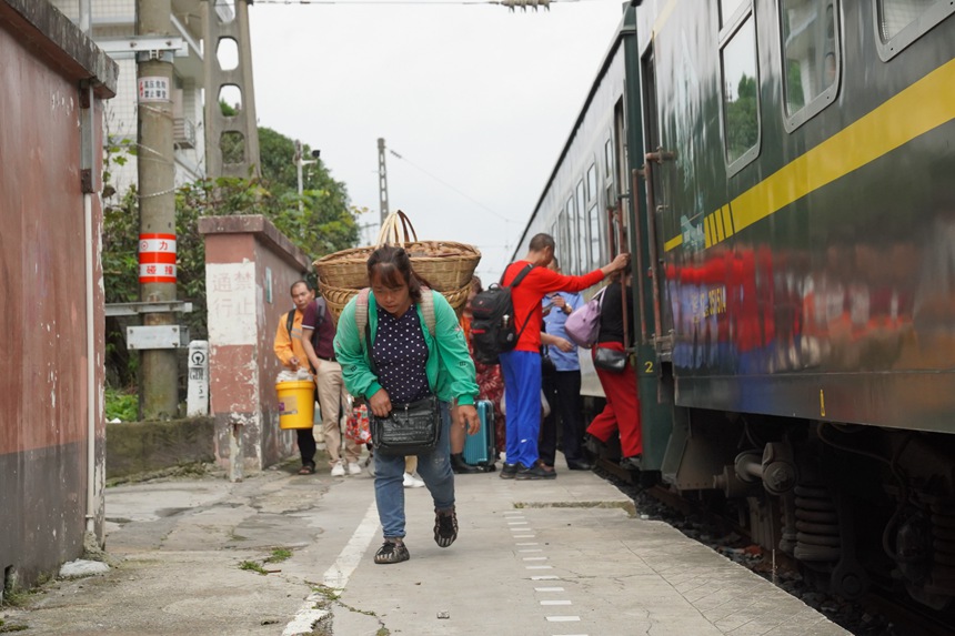 松壩站站臺，旅客背著農(nóng)產(chǎn)品登上小慢車。李文航攝