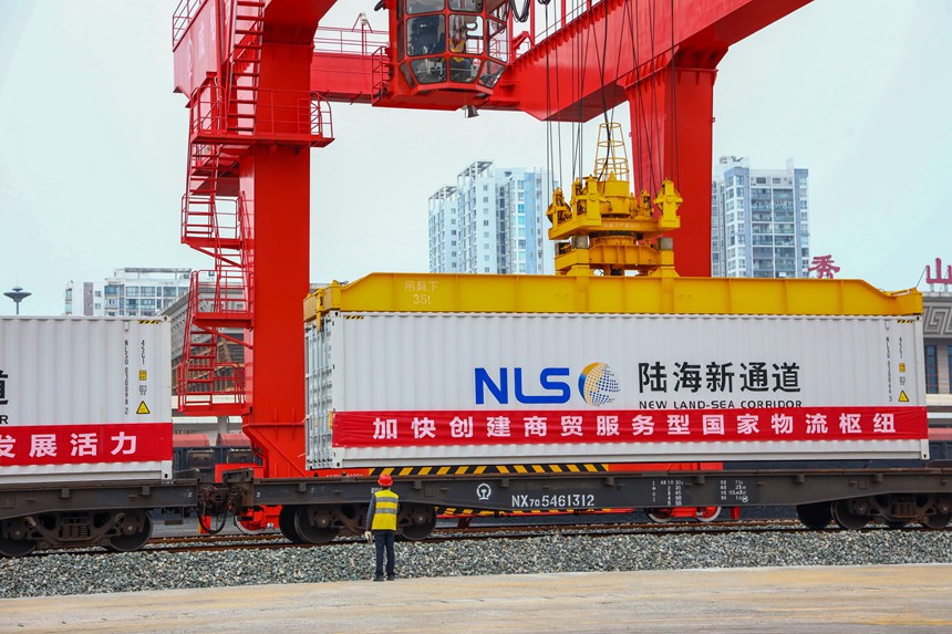 10月12日，秀山站貨場內(nèi)，作業(yè)人員正在盯控龍門吊進(jìn)行吊裝作業(yè)。黃圯攝