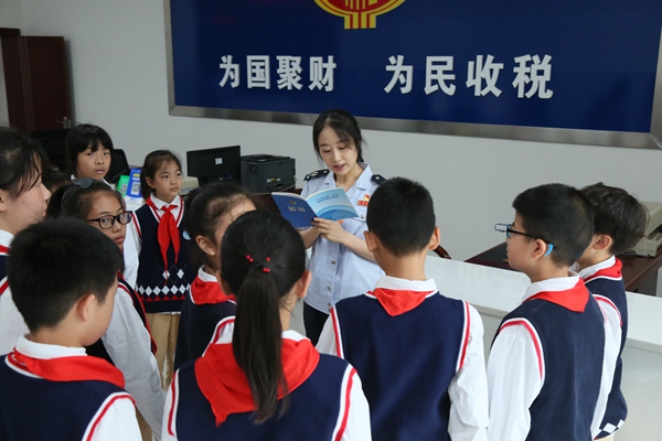 活動(dòng)中，開(kāi)州區(qū)稅務(wù)人員與同學(xué)們互動(dòng)。趙詩(shī)琪攝