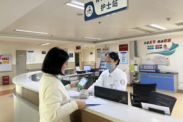 患者家屬在骨關(guān)節(jié)外科護(hù)士站辦理出院結(jié)算手續(xù)。重慶大學(xué)附屬江津醫(yī)院供圖