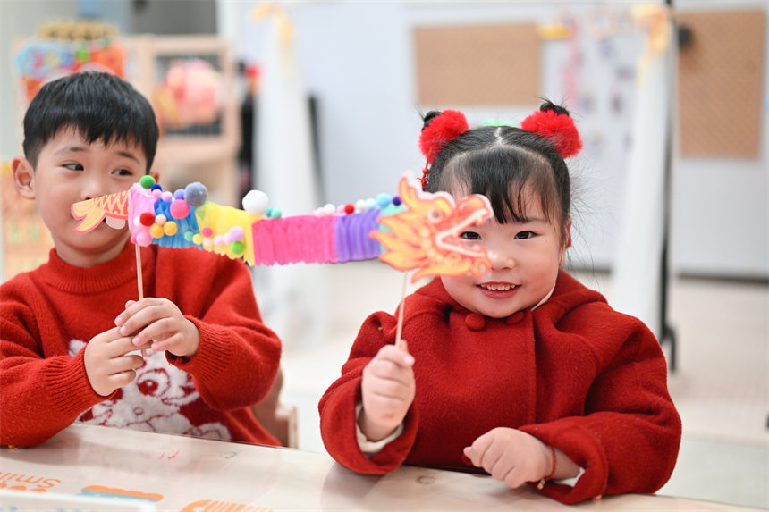 小朋友展示制作的手工翻花龍。郭旭攝