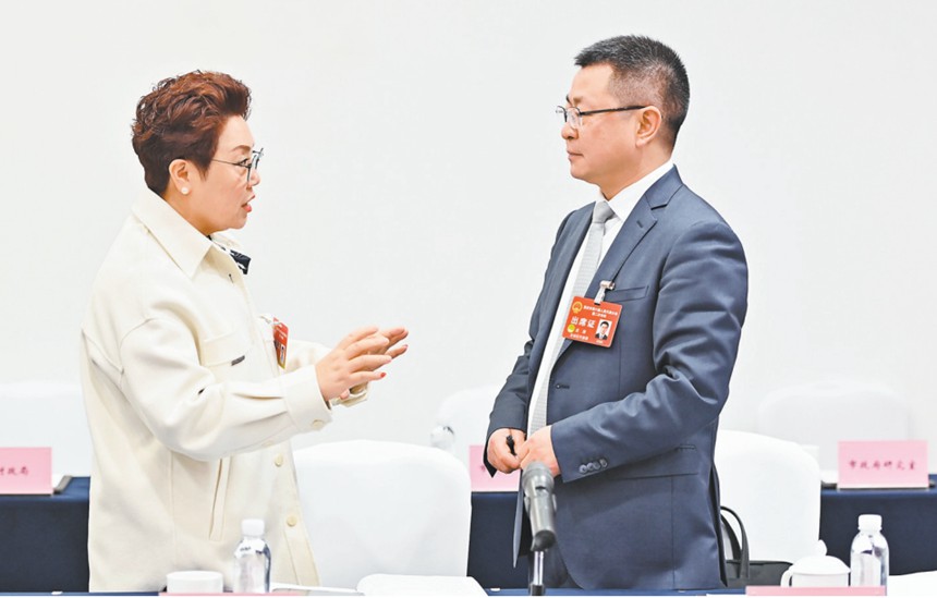 　1月22日，市人大代表在會議間隙就引進(jìn)AI機(jī)器人智能駕培系統(tǒng)的建議展開討論。記者 齊嵐森 攝/視覺重慶