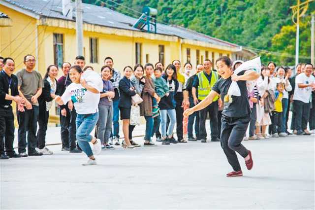 城口縣修齊鎮(zhèn)枇杷村舉辦鄉(xiāng)村趣味運動會，背谷子接力賽、刮洋芋、鋸木頭等活動，引得現(xiàn)場掌聲、笑聲不斷。（受訪者供圖）