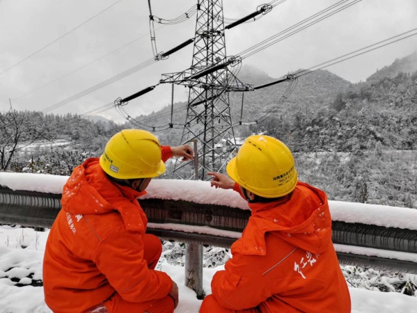 國(guó)家電網(wǎng)紅巖（彭水運(yùn)檢）共產(chǎn)黨員服務(wù)隊(duì)隊(duì)員正在測(cè)積雪厚度。蔡光進(jìn)攝