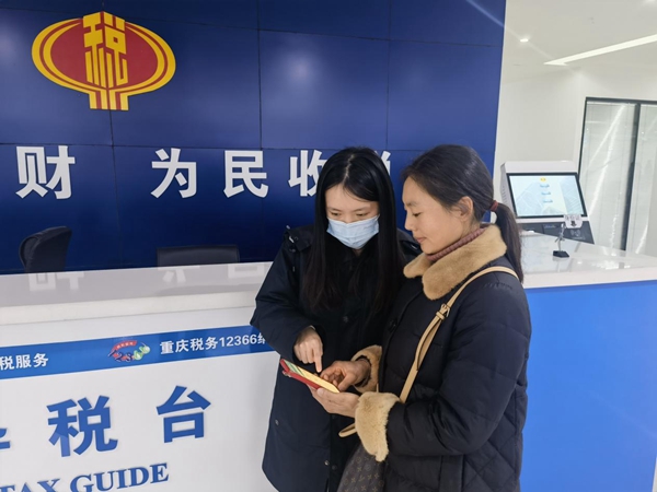 武隆區(qū)稅務(wù)人員輔導(dǎo)群眾在手機(jī)上辦理社保業(yè)務(wù)。侯東攝