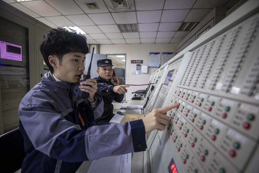 彭聰（右一）在重慶北站消防控制室工作人員的配合下，對車站消防信號設(shè)備進(jìn)行測試。胡勇攝