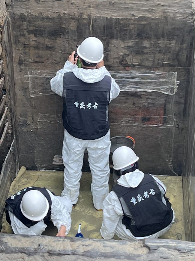 考古人員在墓內(nèi)清理槨板壁畫(huà)。黃偉 攝