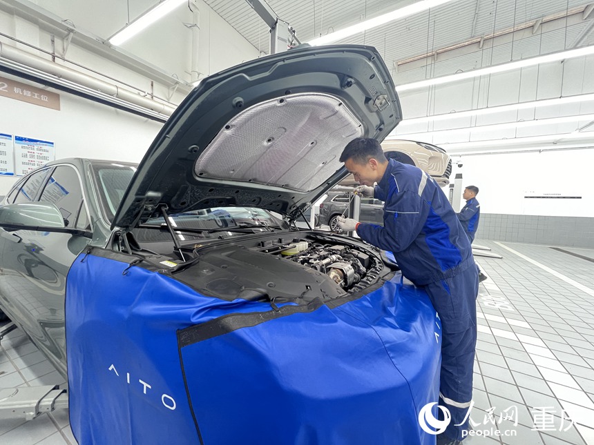 張甲震在為新能源汽車做保養(yǎng)。人民網(wǎng)記者 胡虹攝