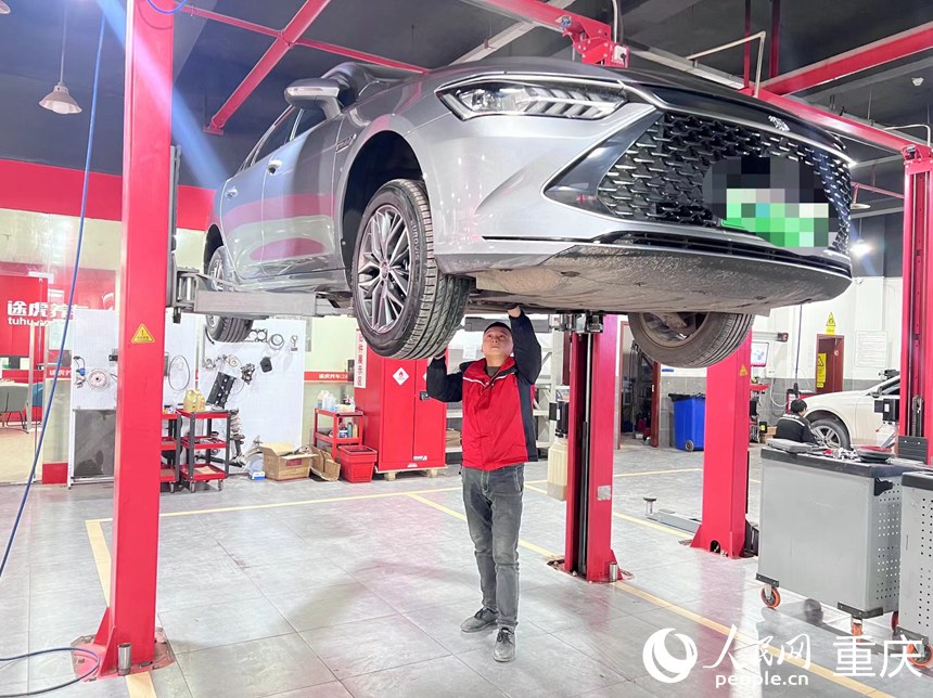 冉清兵在檢查新能源汽車底盤。人民網(wǎng)記者 胡虹攝