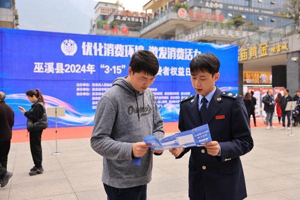 3月15日，在巫溪縣水園商城，稅務(wù)人員正為市民講解發(fā)票維權(quán)相關(guān)內(nèi)容。肖镕攝