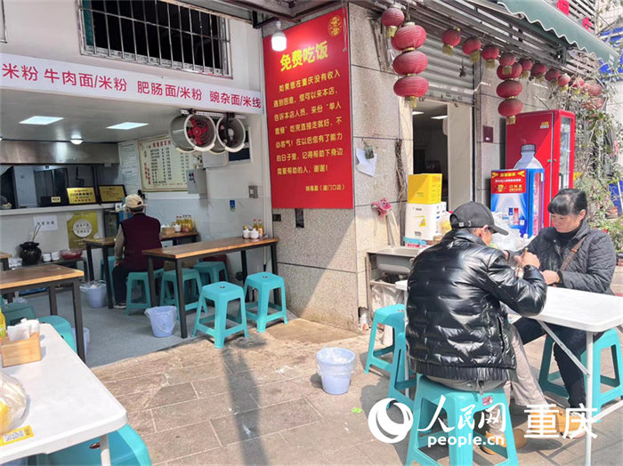 “免費(fèi)吃飯”的告示就貼在餐館入口右邊的墻上，紅底黃字十分醒目。人民網(wǎng) 馮文彥 攝