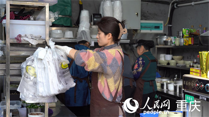 中午時(shí)分，店主何女士正在莽著給顧客備餐。人民網(wǎng) 劉祎攝