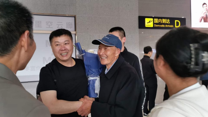 唐啟明在機(jī)場(chǎng)與親人共敘親情。重慶合川區(qū)公安分局供圖