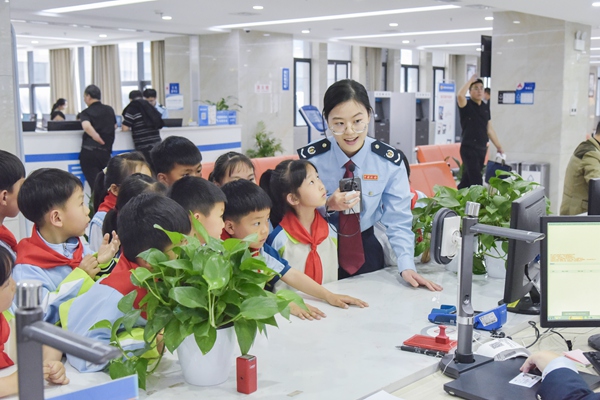 在奉節(jié)縣辦稅服務(wù)廳，稅務(wù)人員帶領(lǐng)“小小稅務(wù)體驗師”參觀辦稅窗口，引導同學們“沉浸式”體驗稅費服務(wù)。蔡仲垚攝