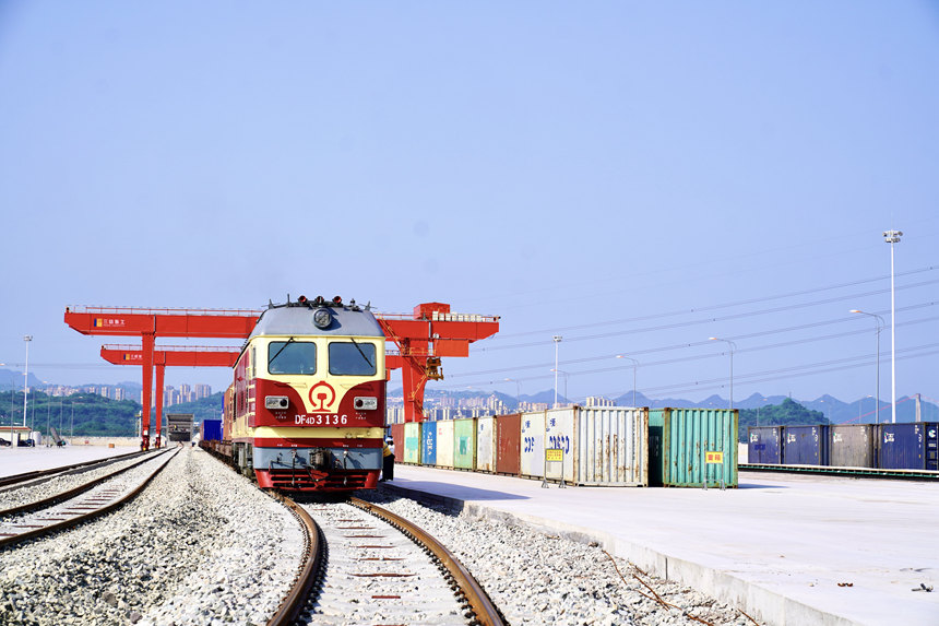 4月28日，重慶涪陵龍頭港，一列搭載著精己二酸、聚酯切片等貨物的西部陸海新通道集裝箱班列緩緩駛出。涪陵車務(wù)段供圖