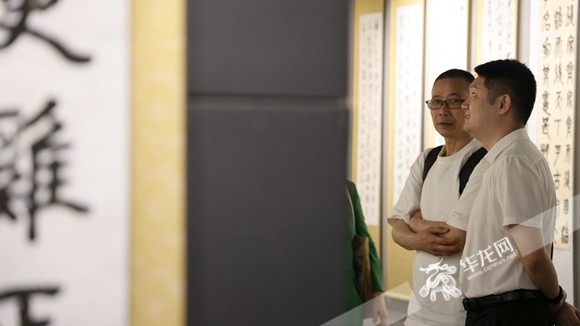 書(shū)畫(huà)展觀眾認(rèn)真觀賞作品。華龍網(wǎng)記者 李燊 攝