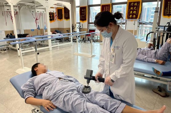 醫(yī)護(hù)人員幫助王阿姨進(jìn)行康復(fù)治療。重慶西區(qū)醫(yī)院供圖