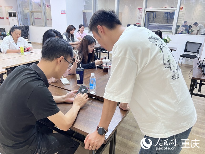 龍門夜校老師正在給青年學(xué)員講解視頻剪切技巧。 人民網(wǎng)記者 胡虹攝