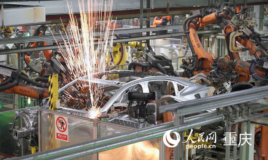 火花迸射，機(jī)械臂正在工作。人民網(wǎng)記者 劉祎攝