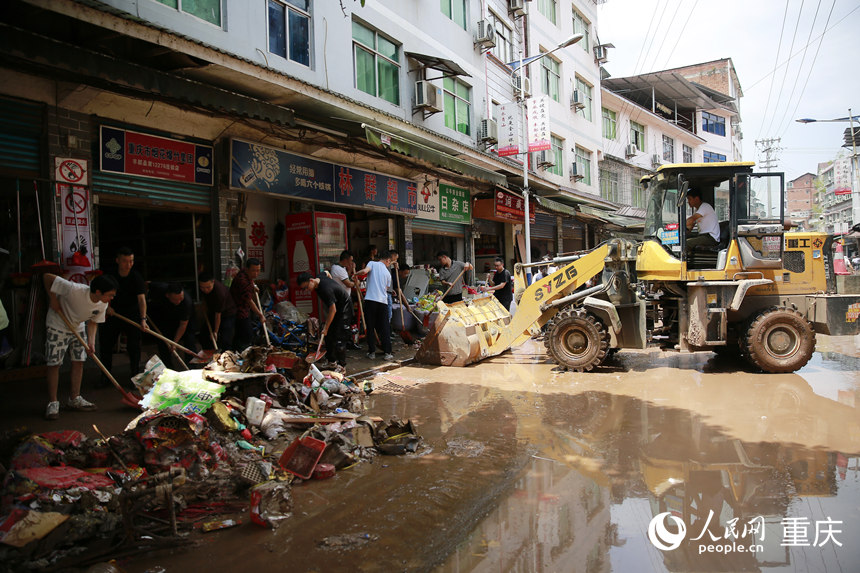 7月12日，志愿者和群眾合力清理仁沙鎮(zhèn)場鎮(zhèn)的淤泥和雜物。人民網(wǎng)記者 劉政寧攝
