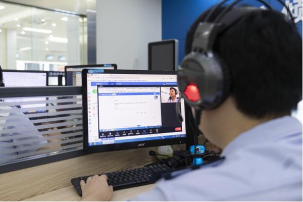 重慶市渝北區(qū)稅務人員通過遠程虛擬窗口，輔導辦事人員。郭睿攝