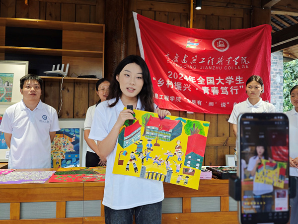 直播中，團(tuán)隊(duì)成員講解磨子鄉(xiāng)優(yōu)秀土家畫(huà)作品。胥潔蘭攝