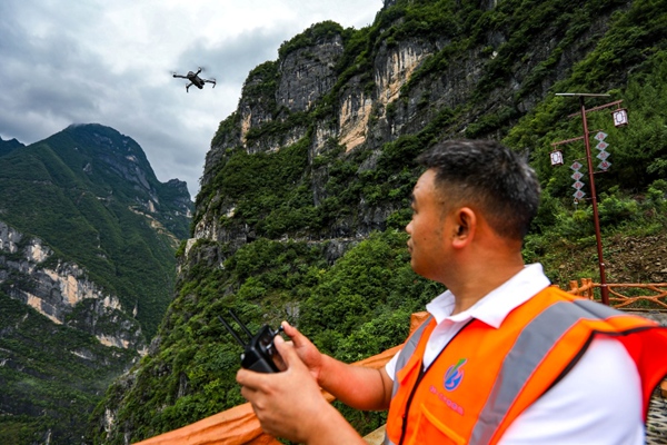 《科技巡查 排除險(xiǎn)患》。7月5日，巫溪縣蘭英鄉(xiāng)掛壁天路，地災(zāi)駐守單位重慶一三六地質(zhì)隊(duì)隊(duì)員使用無人機(jī)進(jìn)行排查工作。尹詩語攝
