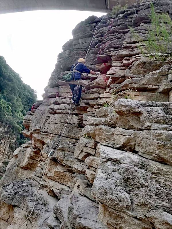 《為地災(zāi)防治事業(yè)練成飛檐走壁》。2023年8月，涪陵區(qū)烏江巖體劣化調(diào)查項(xiàng)目中，南江地質(zhì)隊(duì)高空作業(yè)人員正在懸崖壁上建設(shè)測(cè)窗監(jiān)測(cè)點(diǎn)。向棋攝