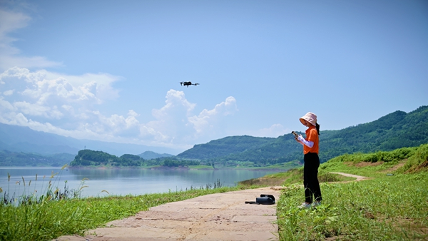 《巾幗有擔(dān)當(dāng)》。8月6日，107地質(zhì)隊(duì)地質(zhì)工程師劉爽在萬州區(qū)武陵鎮(zhèn)江灣區(qū)域開展無人機(jī)航拍工作。傅林?jǐn)z