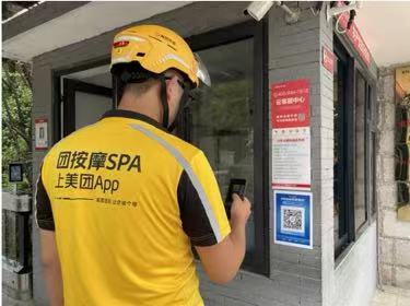 騎手在小區(qū)入口處掃碼可一鍵登記快捷通行。金科服務(wù)供圖